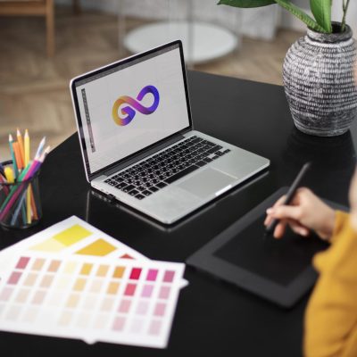 weibliche-logo-designerin-die-ihrem-tablet-arbeitet-das-mit-einem-laptop-verbunden-ist